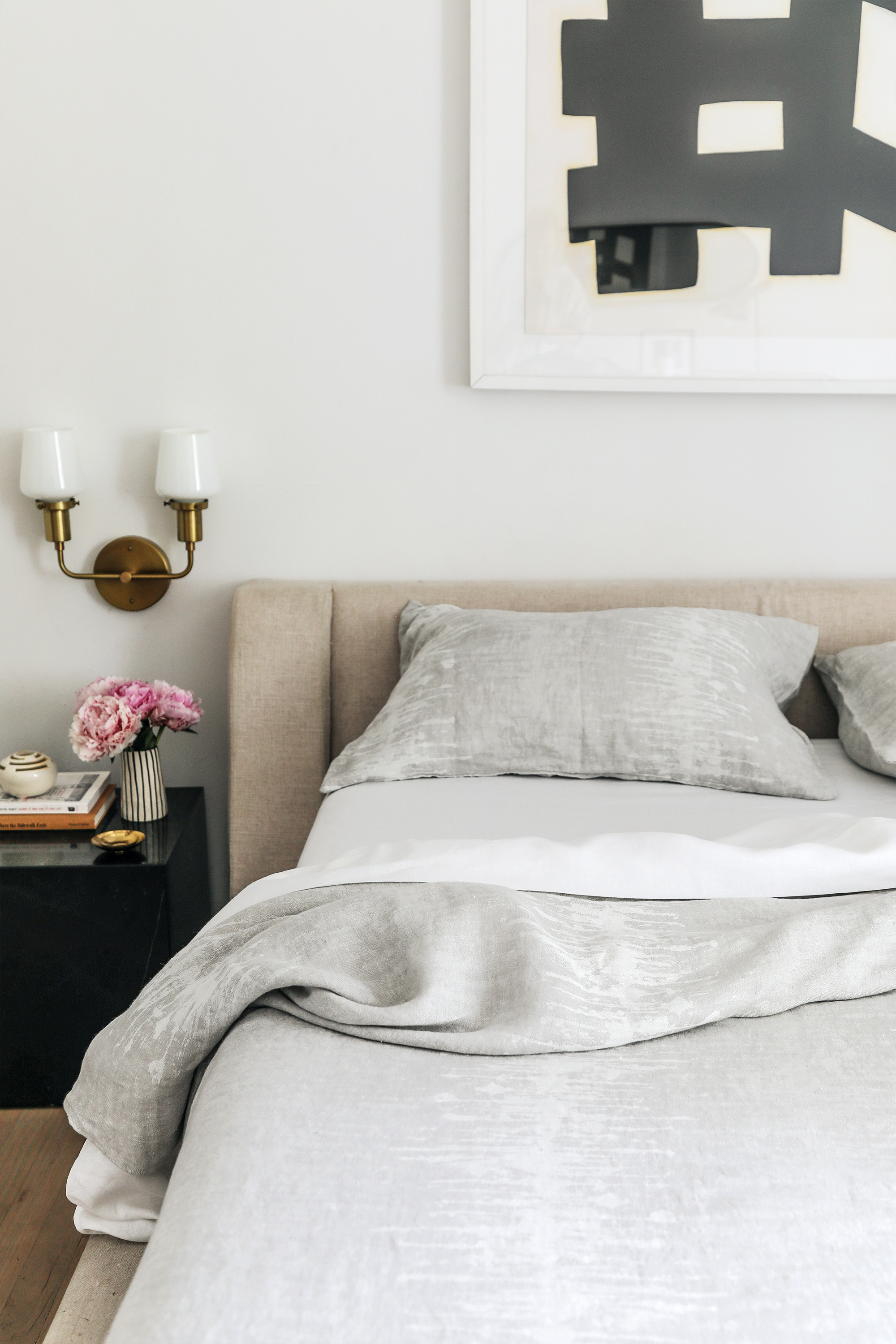 modern bedroom with upholstered headboard and linen bedding 