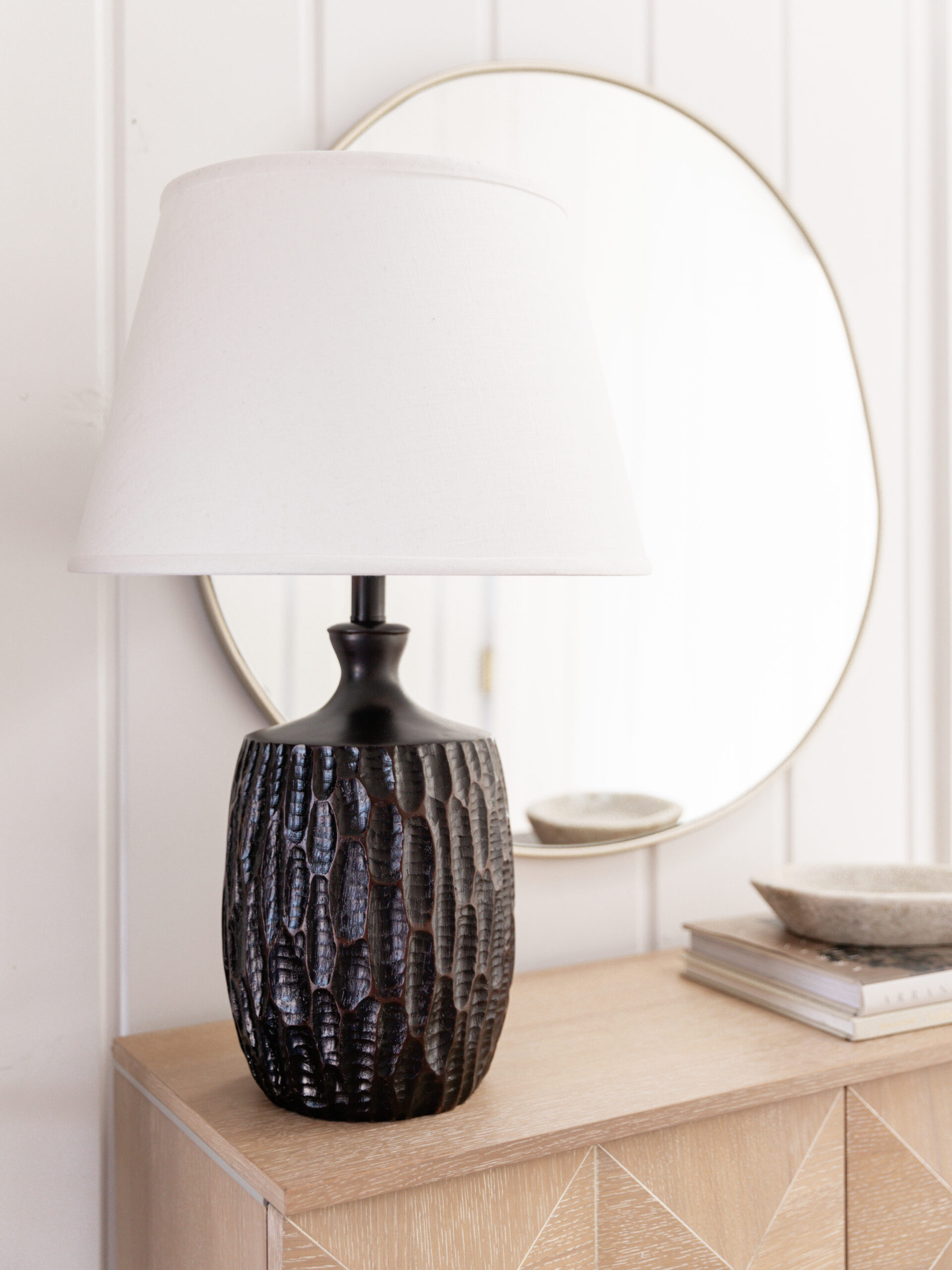 modern lamp and mirror on an entryway table
