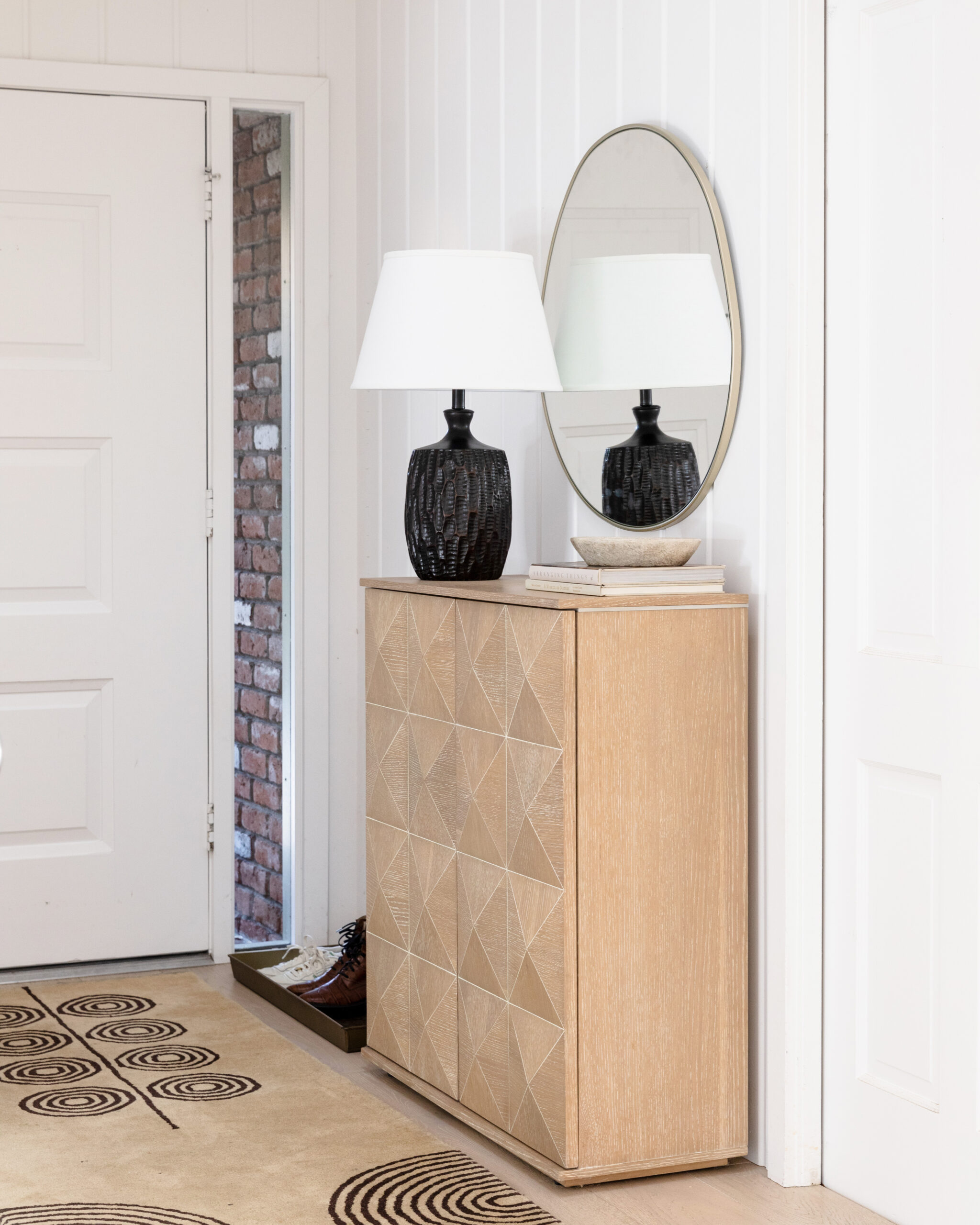 modern entryway with cabinet mirror and lamp